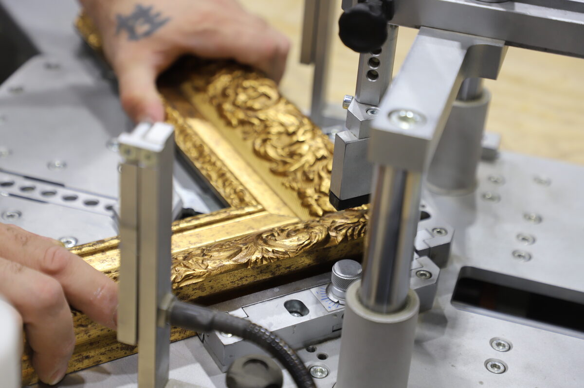 A gold ornate frame being assembled on our production line
