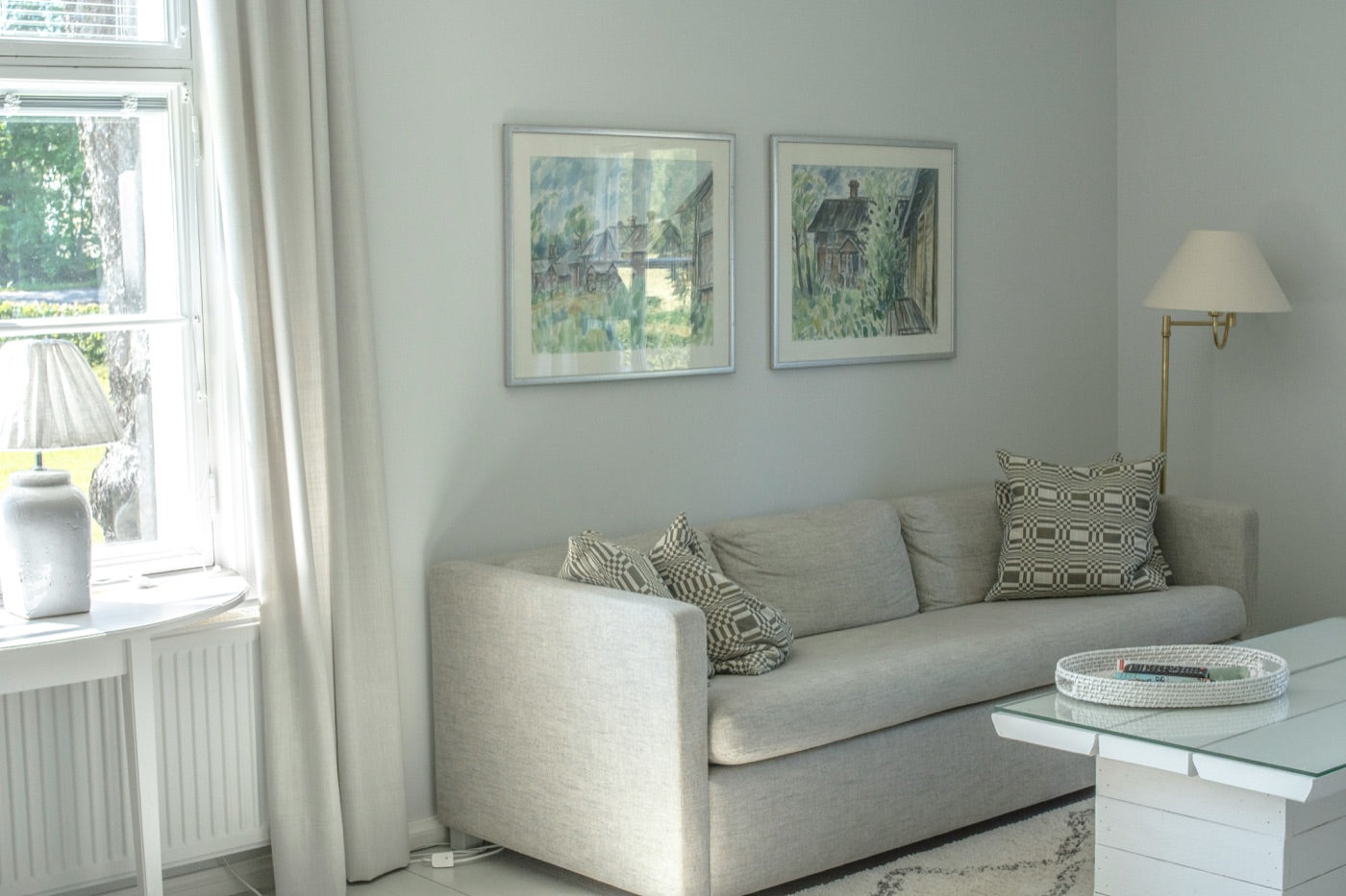 Two framed prints hung with balanced spacing above a sofa