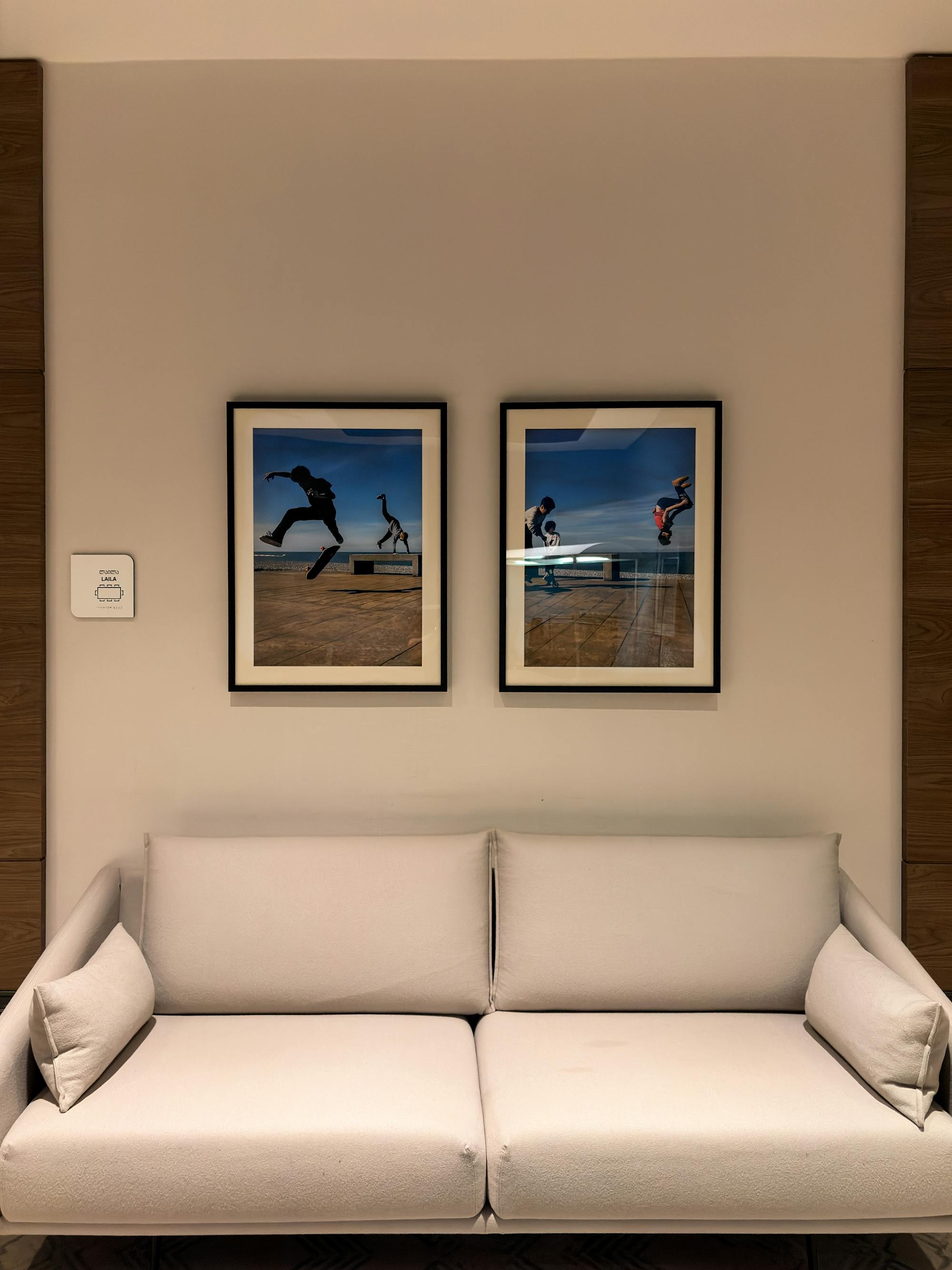 Two framed action photographs above a sofa in a minimalist living room